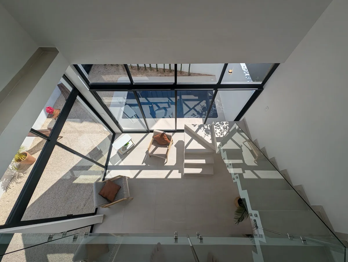 Floating glass staircase seen from the upper floor