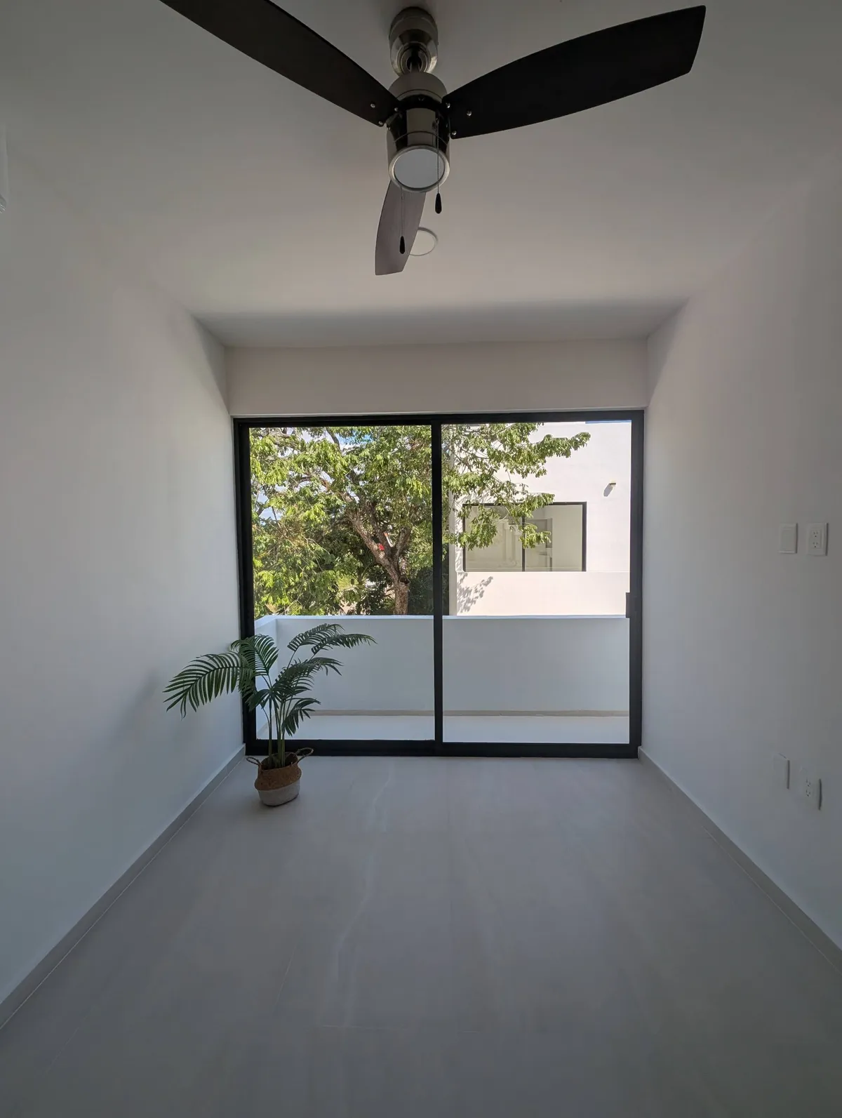 Bedroom with a ceiling fan and sliding doors to the balcony