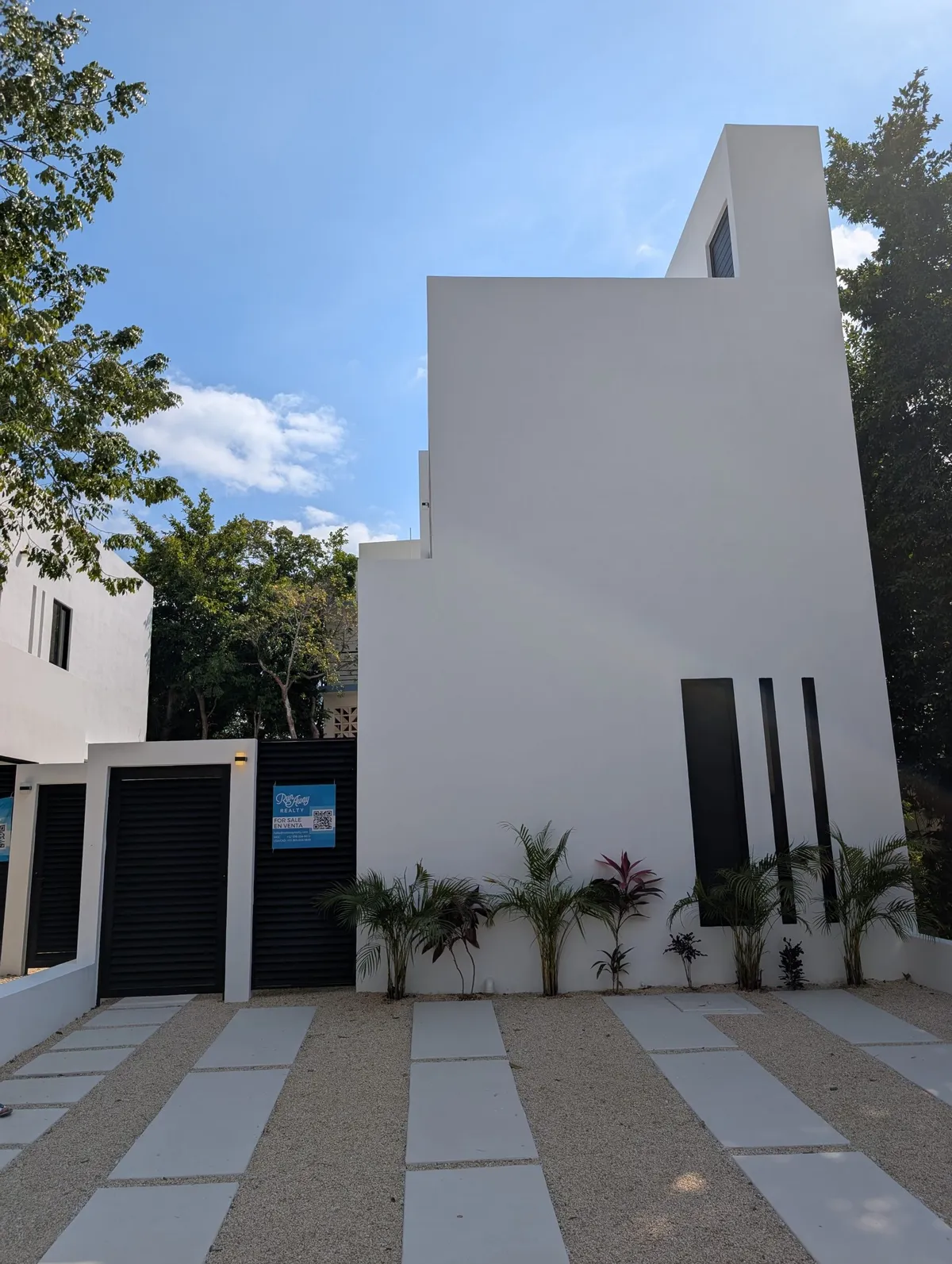 Street view of the home with a landscaped walkway in the Puntarena community
