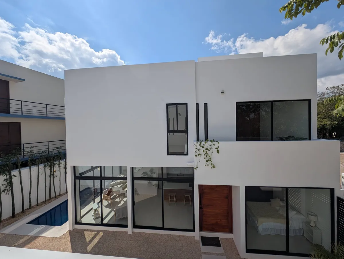 Rear facade of the Vida Azul home with floor-to-ceiling windows and a dipping pool